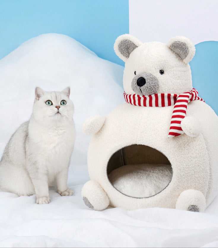 Cat sitting beside Polar Bear Cat Bed - Cozy Winter Retreat, a plush indoor cat furniture piece shaped like a bear with a scarf.