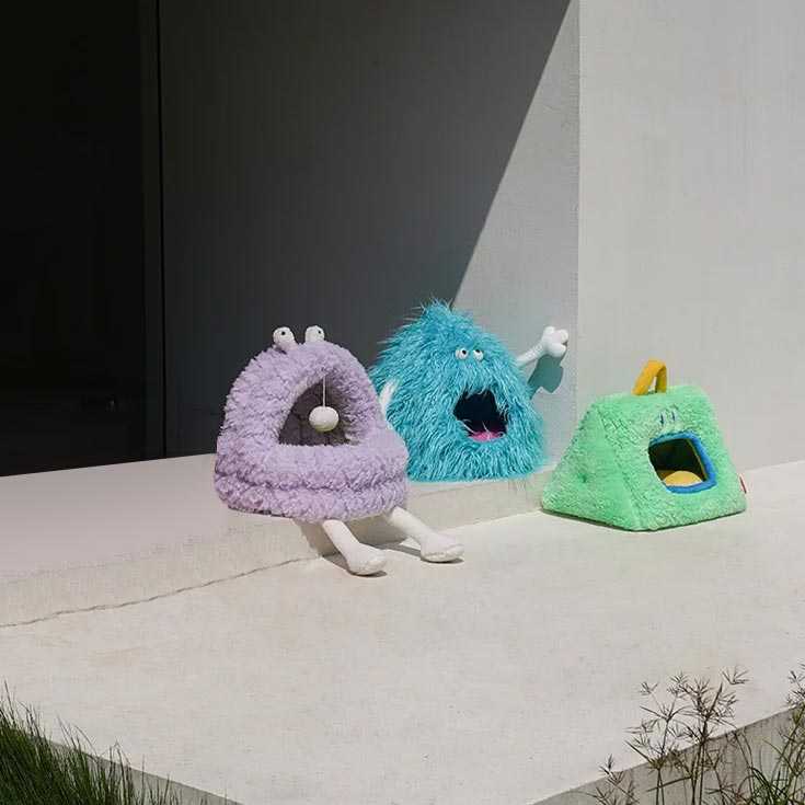 Three Monster Series Cat Beds in purple, blue, and green displayed on a ledge, showcasing variety in fun and cozy cat furniture.