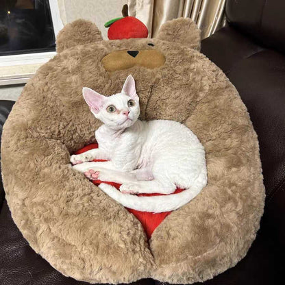 White cat relaxing in Apple Bear Hug Cat Bed with soft brown bear design and red cushion for comfort.