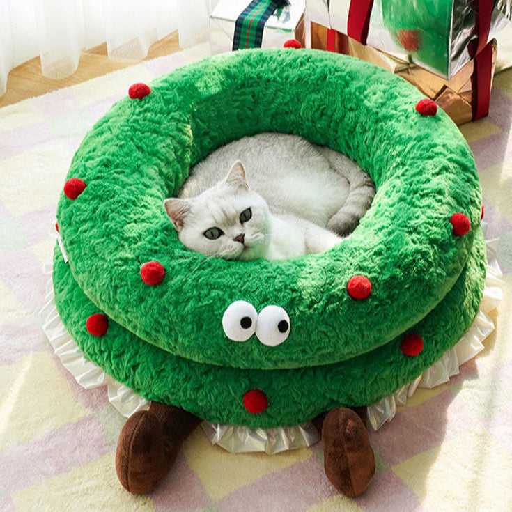 White cat relaxing inside the Christmas Wreath Shaped Cat Bed, showcasing cozy design and holiday-themed pet furniture.