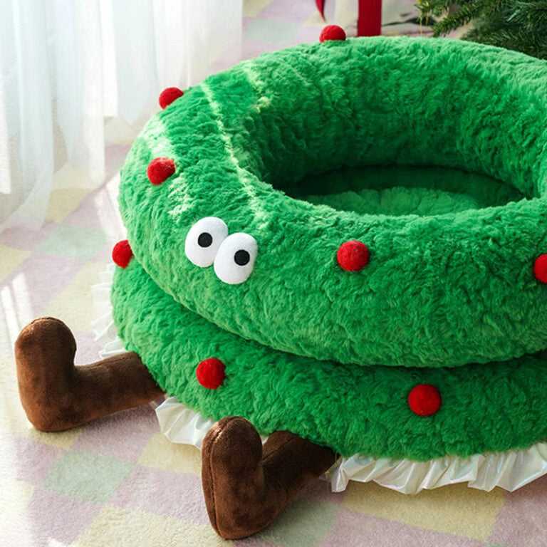 Close-up of Christmas Wreath Shaped Cat Bed featuring soft green texture, red accents, and brown plush legs for festive cat lounging.