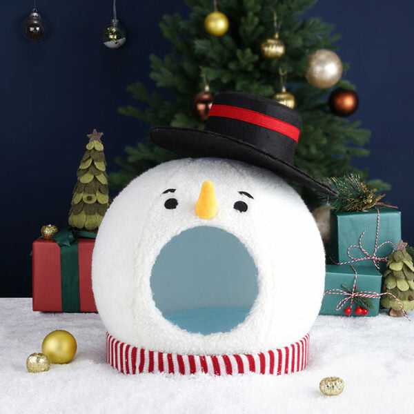 Empty Snowman Cat Covered Bed with striped base and black hat, displayed in front of Christmas tree and presents.