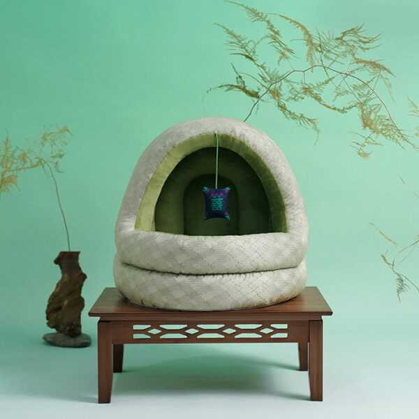Green Pine Cave Cat Bed - Japanese Design placed on wooden table, highlighting its stylish and compact cat furniture appeal.