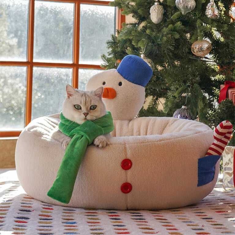 Cat sitting in Hug Snowman Cat Bed under Christmas tree, showcasing cozy and festive cat furniture for winter seasons.