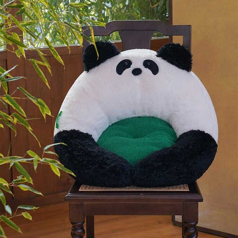 Panda Hug Cat Bed placed on a wooden chair, showcasing its round panda design with green inner cushion for stylish cat comfort.