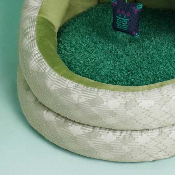 Interior view of Green Pine Cave Cat Bed - Japanese Design, showing green cushion and hanging toy for cat relaxation.