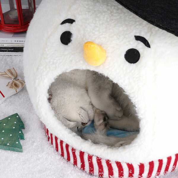 Cat sleeping curled inside Snowman Cat Covered Bed, highlighting soft interior and snug winter pet shelter.