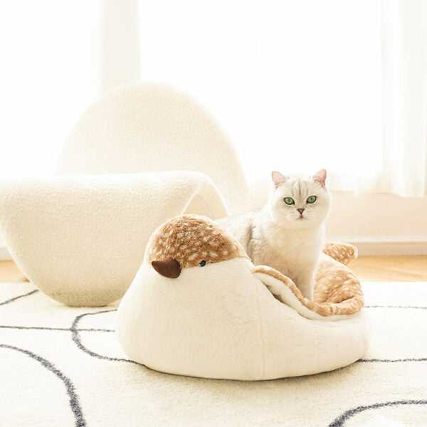 White cat sitting in Sparrow Cat Bed shaped like a bird, ideal for modern pet-friendly interiors. Soft and decorative cat furniture.