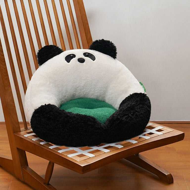 Panda Hug Cat Bed on a wooden chair, emphasizing its plush panda shape and ergonomic green cushion for cat lounging.