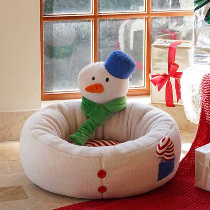 Hug Snowman Cat Bed placed near window with gift boxes, featuring plush snowman and striped cushion for festive cat lounging.