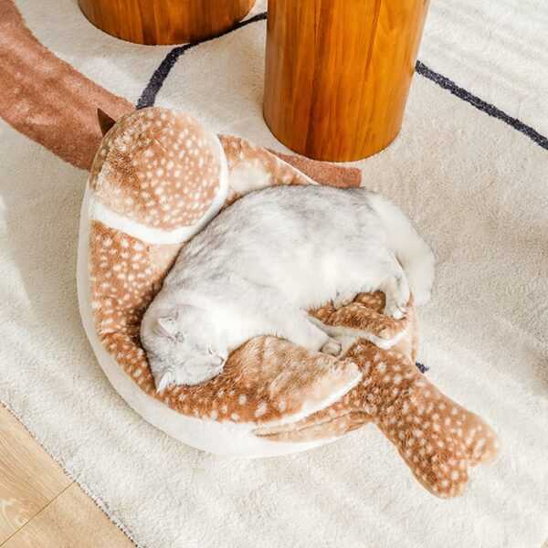Top view of a cat sleeping in the Sparrow Cat Bed with plush bird shape. Comfortable and decorative cat bed for indoor use.