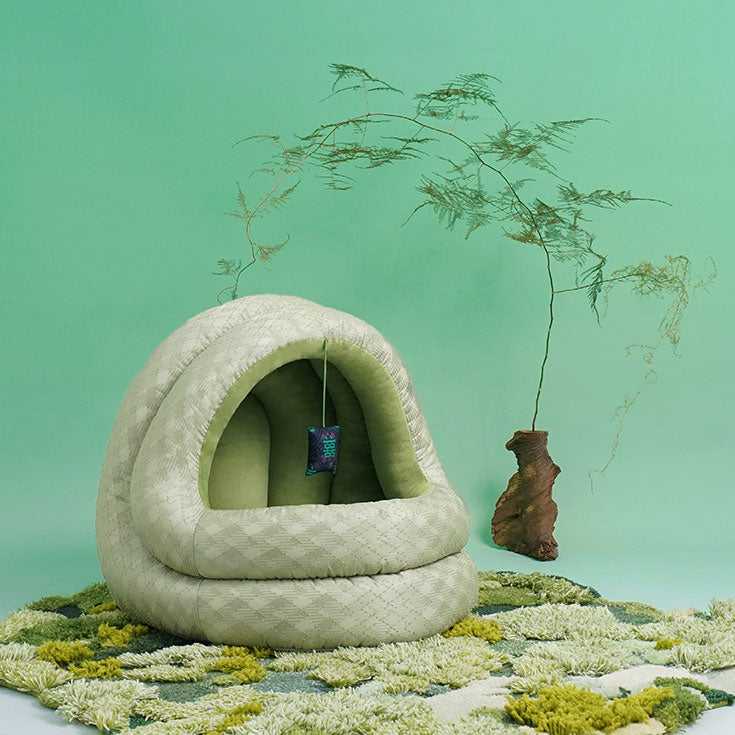 Empty Green Pine Cave Cat Bed - Japanese Design on green rug, showcasing its elegant dome shape and cozy interior.