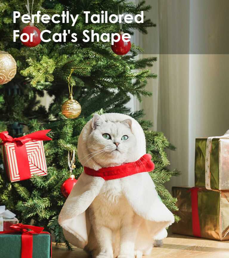 White cat in snowman cape from Gift Set Cat Christmas Costumes, perfectly tailored fit, posing by Christmas tree and gifts.